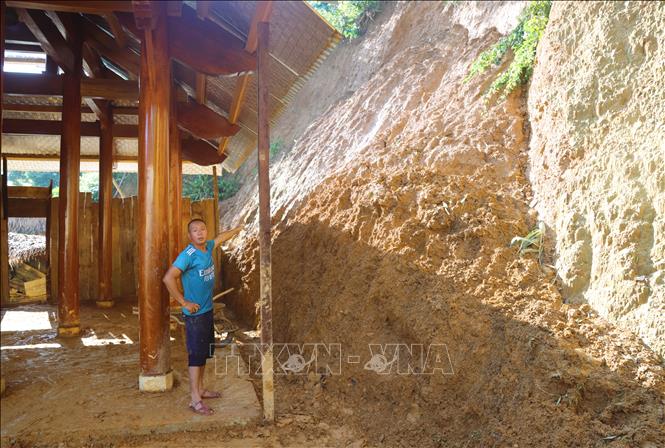 Sạt lở vách ta-luy dương sau nhà khiến một lượng lớn bùn, đất tràn vào nhà dân, gây hư hỏng các bức tường bằng ván gỗ xung sau nhà. Ảnh: Xuân Tiến - TTXVN 