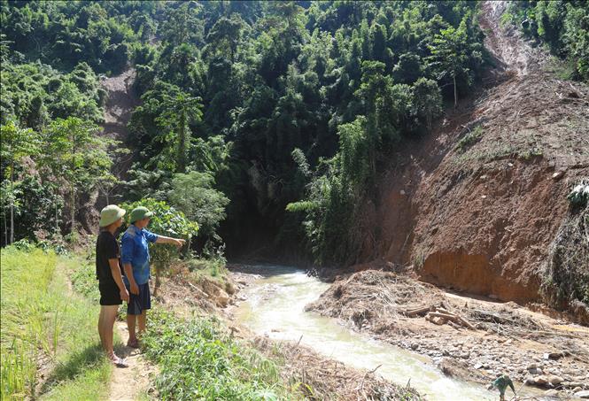 Vị trí có khả năng tạo thành đập dâng ngăn dòng tích nước nếu cung sạt lở đổ sập xuống suối Nậm Ngân. Ảnh: Xuân Tiến - TTXVN 