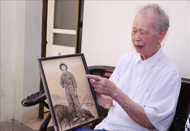 Cựu chiến binh Nguyễn Minh Thắng chia sẻ với phóng viên về bức hình kỷ niệm chiến sỹ Điện Biên, Xuân 1954. Ảnh: Văn Điệp - TTXVN
