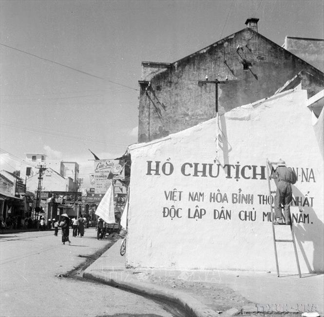 Nhân dân viết khẩu hiệu đón chào bộ đội về giải phóng Thủ đô (1954). Ảnh: Tư liệu TTXVN