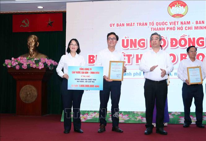 Ông Nguyễn Phước Lộc (phải), Phó Bí thư Thành ủy, Chủ tịch Ủy ban MTTQ Việt Nam Thành phố Hồ Chí Minh tiếp nhận ủng hộ hỗ trợ đồng bào bị thiệt hại bở lũ lụt, thiên tai. Ảnh: Xuân Khu-TTXVN