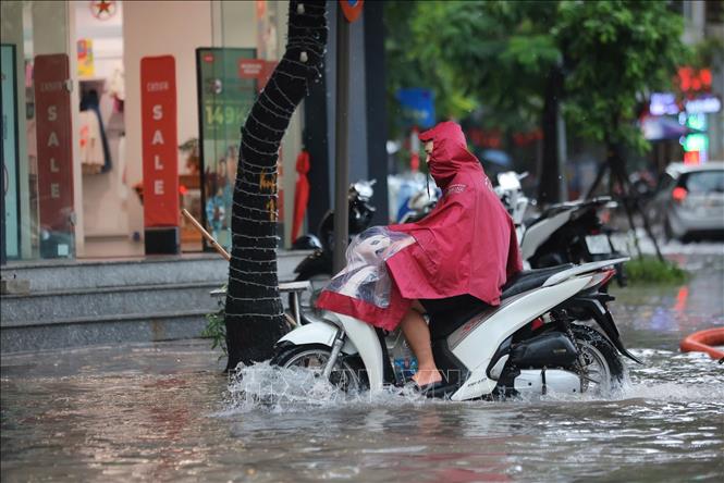 Nước ngập sâu trên phố Nguyễn Du khiến người dân đi lại khó khăn (ảnh chụp lúc 12 giờ 20 phút). Ảnh: Hoàng Hiếu - TTXVN
