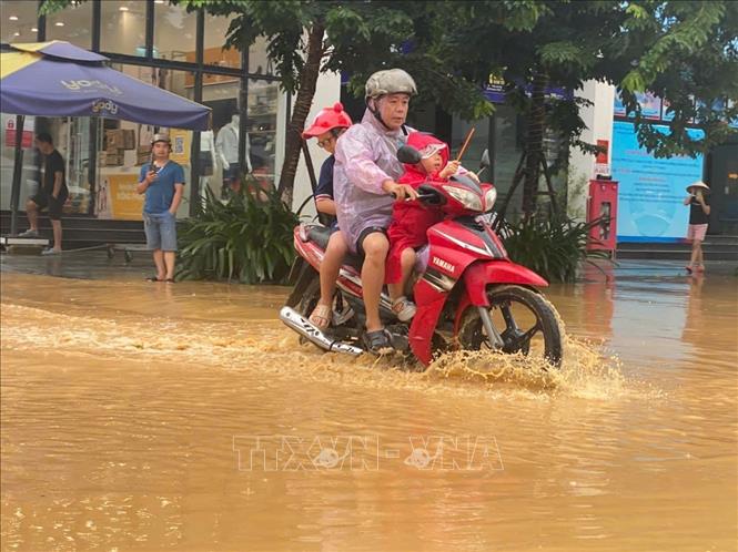 Lũ lên nhanh, người dân phải khẩn cấp sơ tán người già và trẻ em đến nơi an toàn. Ảnh: Quốc Đạt - TTXVN
