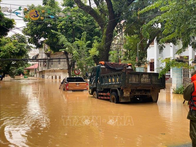 Nước lũ dâng lên quá nhanh khiến nhiều người không kịp sơ tán tài sản đến nơi an toàn. Ảnh: Quốc Đạt - TTXVN