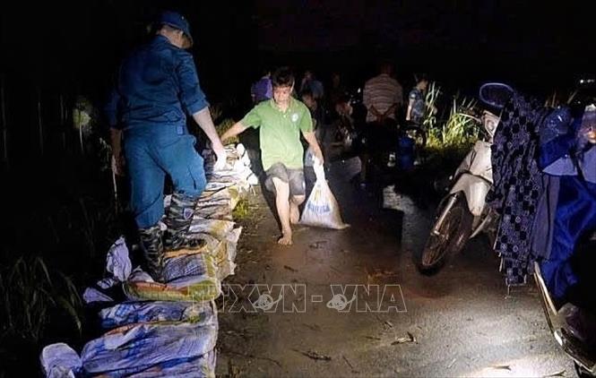 Cán bộ, chiến sĩ Trung đoàn 2, Sư đoàn 3 đóng quân trên địa bàn và nhân dân tổ chức ứng cứu, khắc phục sự cố ngay trong đêm. Ảnh: TTXVN phát