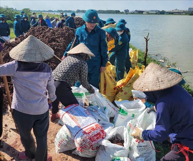 Cán bộ, chiến sĩ Trung đoàn 2, Sư đoàn 3 đóng quân trên địa bàn và nhân dân tổ chức ứng cứu, khắc phục sự cố ngay trong đêm. Ảnh: TTXVN phát