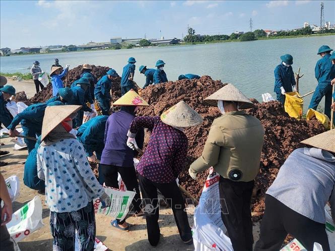 Cán bộ, chiến sĩ Trung đoàn 2, Sư đoàn 3 đóng quân trên địa bàn và nhân dân tổ chức ứng cứu, khắc phục sự cố ngay trong đêm. Ảnh: TTXVN phát