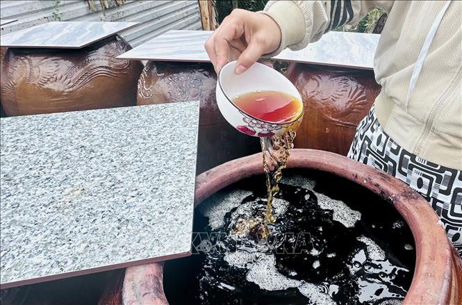 Nước mắm cá linh màu cánh gián, sánh đặc, thơm dịu là thành quả sau hơn hai năm ủ truyền thống. Ảnh: Thanh Sang - TTXVN