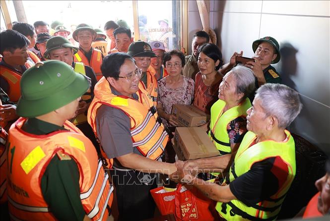 Thủ tướng Phạm Minh Chính chỉ đạo công tác cứu hộ, cứu nạn và động viên nhân dân khu vực ngập lụt tại Thái Nguyên. Ảnh: Dương Giang-TTXVN 
