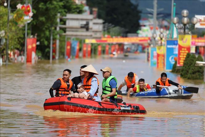 Người dân dùng xuồng cao để di chuyển trên tuyến đường Hoàng Văn Thụ, phường Phan Đình Phùng. Ảnh: Nhật Anh - TTXVN
