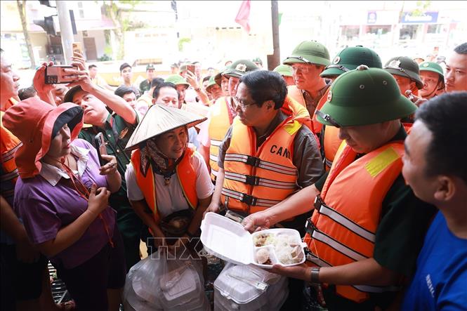 Thủ tướng Phạm Minh Chính thăm hỏi, động viên nhân dân bị ảnh hưởng lũ lụt tại khu vực phường Phan Đình Phùng, tỉnh Thái Nguyên. Ảnh: Dương Giang-TTXVN 
