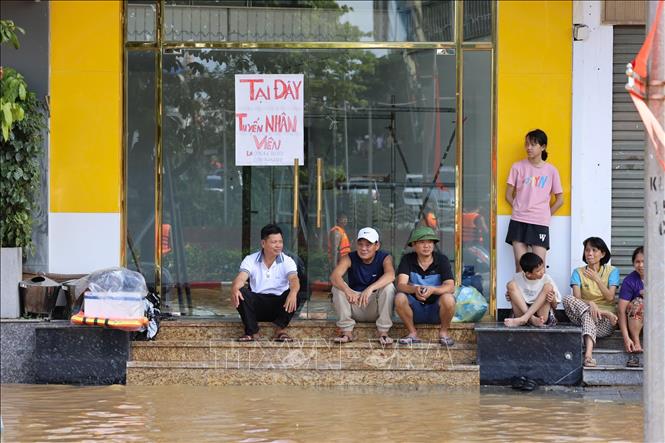 Người dân ngồi trên các bậc thềm, ngao ngán chờ nước rút là cảnh tượng được nhìn thấy ở khắp nơi tại khu vực trung tâm tỉnh Thái Nguyên mấy ngày qua. Ảnh: Nhật Anh-TTXVN