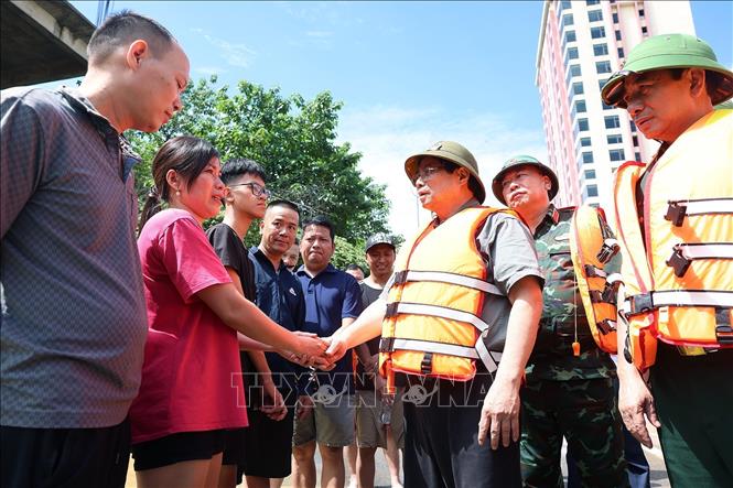 Thủ tướng Phạm Minh Chính thăm hỏi, động viên nhân dân bị ảnh hưởng lũ lụt tại khu vực phường Phan Đình Phùng, tỉnh Thái Nguyên. Ảnh: Dương Giang-TTXVN 

