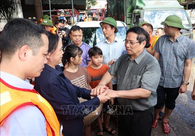 Thủ tướng Phạm Minh Chính thăm hỏi, động viên nhân dân bị ảnh hưởng lũ lụt tại phường Phan Đình Phùng. Ảnh: Dương Giang-TTXVN 
