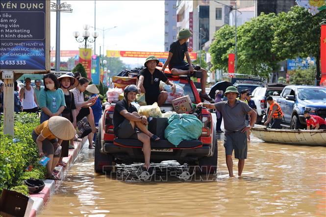 Phương tiện chở đồ tiếp tế cho người dân khu vực ngập lụt ở phường Phan Đình Phùng chờ xuồng để chuyển đi. Ảnh: Nhật Anh-TTXVN