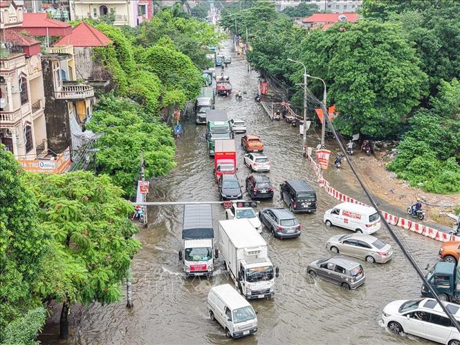 Đoạn ngã tư khu vực Cầu Bươi, Phạm Tu vẫn ngập từ 30 - 40 cm, ảnh hưởng nhiều đến việc đi lại của nhân dân. Ảnh: Hoàng Hiếu - TTXVN