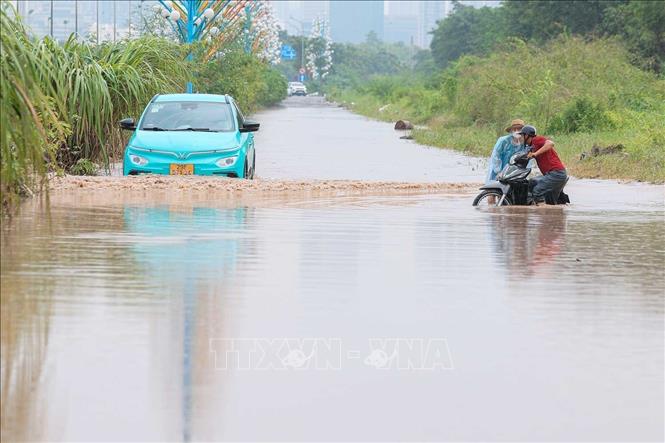Lối độc đạo vào Miêu Nha, phường Xuân Phương vẫn ngập sâu, khiến nhiều xe chết máy khi cố gắng di chuyển. Ảnh: Hoàng Hiếu - TTXVN