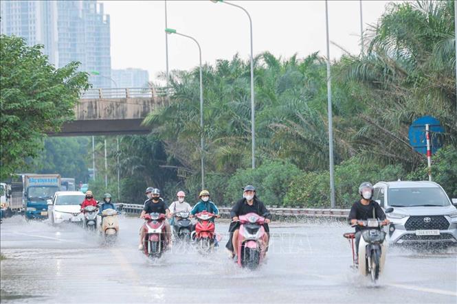 Xe máy, ô tô đi vào lối dành riêng cho ô tô trên đại lộ Thăng Long do đường dành cho xe máy bị ngập. Ảnh: Hoàng Hiếu - TTXVN