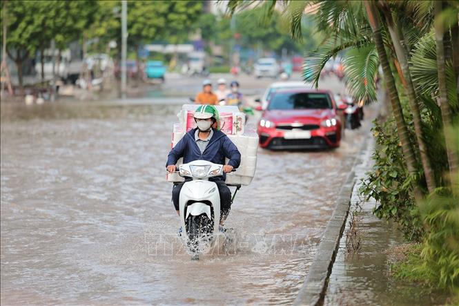 Các phương tiện lưu thông khó khăn đoạn đường Dương Đình Nghệ giao với đường Phạm Hùng. Ảnh: Lê Đông - TTXVN
