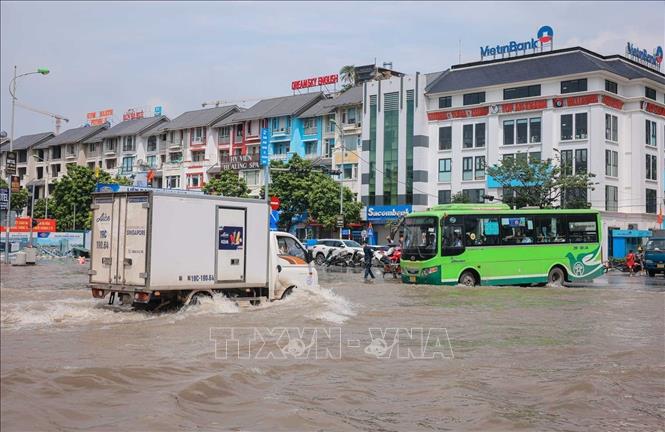 Người dân di chuyển khó khăn khi đi qua các điểm ngập trong Khu đô thị An Khánh. Ảnh: Hoàng Hiếu - TTXVN