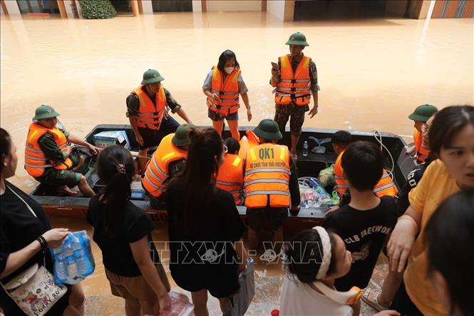 Đoàn cứu hộ Quân khu 1 vận chuyển nước uống đến cho người dân bị cô lập bởi nước lũ ở phường Phan Đình Phùng, tỉnh Thái Nguyên. Ảnh: Nhật Anh - TTXVN