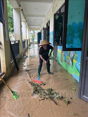 Dọn dẹp vệ sinh môi trường sau khi nước rút tại một trường học ở phường Vân Hà, tỉnh Bắc Ninh. Ảnh: TTXVN phát
