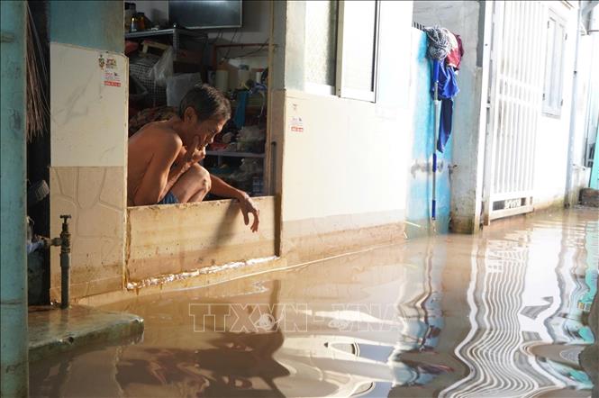 Người dân dùng vật dụng che chắn để nước không tràn vào nhà. Ảnh: Thanh Liêm - TTXVN