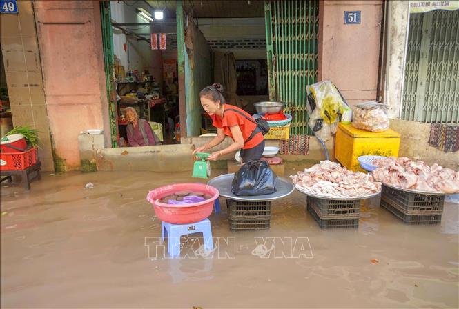 Tiểu thương ở chợ Bình Thủy buôn bán ế ẩm khi triều cường lên cao gây ngập sâu. Ảnh: Thanh Liêm - TTXVN