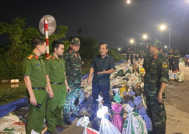 Chủ tịch UBND phường Kinh Bắc Nguyễn Mạnh Hiếu chỉ đạo gia cố đê bối Đẩu Hàn đêm 8/10. Ảnh: TTXVN