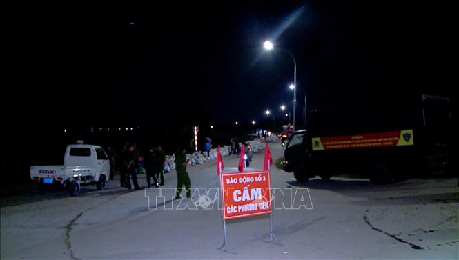 Các lực lượng phối hợp với nhân dân địa phương gia cố đê bối Đẩu Hàn đêm 8/10/2025. Ảnh: TTXVN