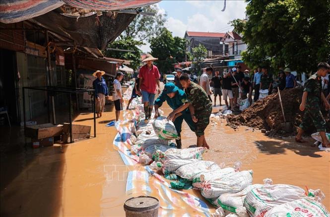 Lực lượng vũ trang Quân khu 1 cùng nhân dân thôn Ngô Đạo, xã Đa Phúc (Hà Nội) tiến hành các biện pháp gia cố đê Hữu Cầu. Ảnh: Hoàng Hiếu - TTXVN