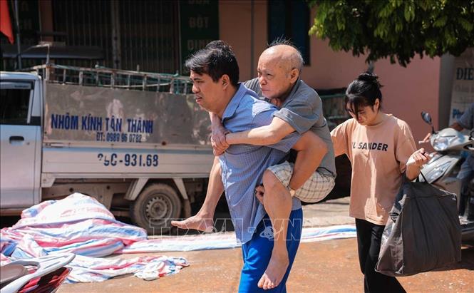 Người dân được di chuyển đến nơi an toàn khi nước sông Cầu dâng cao. Ảnh: Hoàng Hiếu - TTXVN