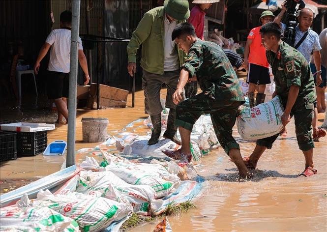 Lực lượng quân đội Quân khu 1 cùng nhân dân thôn Ngô Đạo, xã Đa Phúc (Hà Nội) đang gia cố đê Hữu Cầu. Ảnh: Hoàng Hiếu - TTXVN
