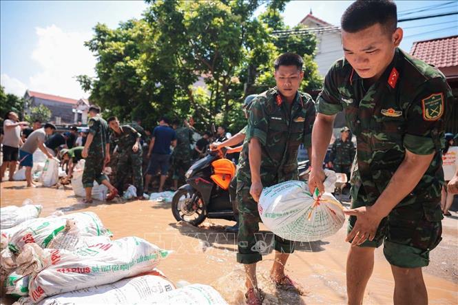 Lực lượng quân đội Quân khu 1 cùng nhân dân thôn Ngô Đạo, xã Đa Phúc (Hà Nội) đang gia cố đê Hữu Cầu. Ảnh: Hoàng Hiếu - TTXVN