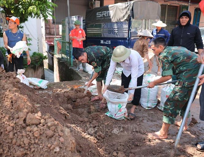 Lực lượng quân đội Quân khu 1 cùng nhân dân thôn Ngô Đạo, xã Đa Phúc (Hà Nội) đang gia cố đê Hữu Cầu. Ảnh: Hoàng Hiếu - TTXVN