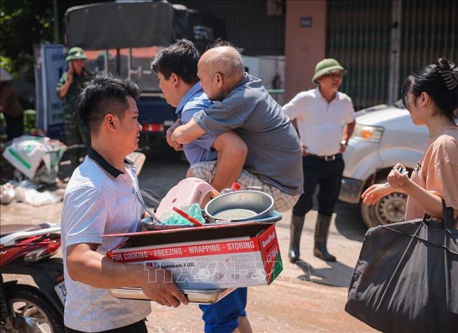 Người dân thôn Ngô Đạo, xã Đa Phúc ,Hà Nội di chuyển tài sản khỏi nơi bị ngập. Ảnh: Hoàng Hiếu - TTXVN
