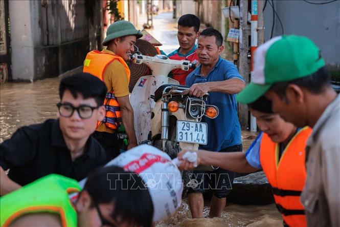 Người dân thôn Ngô Đạo, xã Đa Phúc, Hà Nội, di chuyển tài sản khỏi vùng bị ngập. Ảnh: Hoàng Hiếu - TTXVN