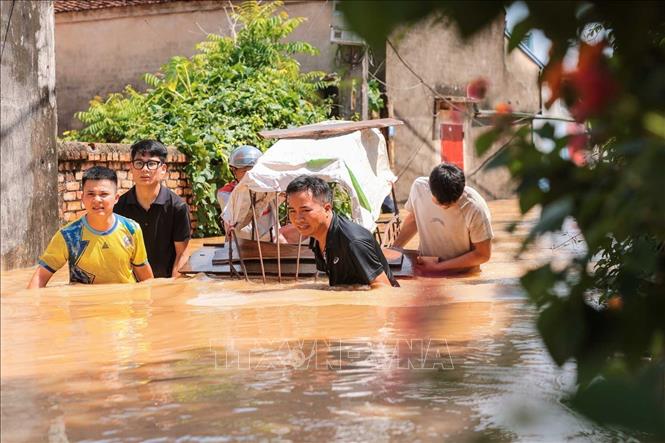 Người dân thôn Ngô Đạo, xã Đa Phúc, Hà Nội, di chuyển tài sản khỏi vùng bị ngập. Ảnh: Hoàng Hiếu - TTXVN