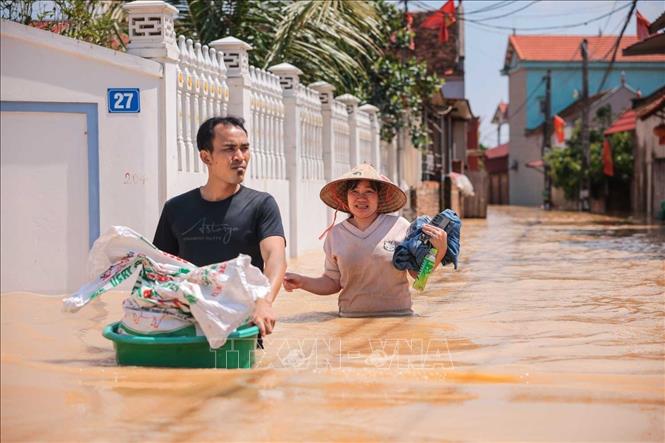 Người dân thôn Ngô Đạo, xã Đa Phúc, Hà Nội, di chuyển tài sản khỏi vùng bị ngập. Ảnh: Hoàng Hiếu - TTXVN