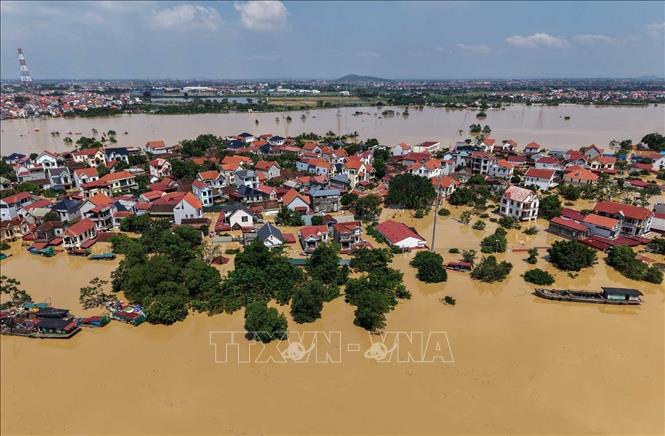 Nước ngập sâu khiến nhiều ngôi nhà chỉ còn nhìn thấy mái. Ảnh: Hoàng Hiếu-TTXVN