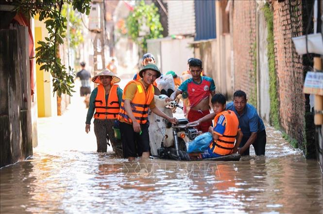 Người dân thôn Ngô Đạo, xã Đa Phúc, Hà Nội di chuyển người, tài sản khỏi khu vực bị ngập nặng. Ảnh: Hoàng Hiếu - TTXVN