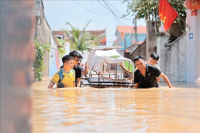 Người dân thôn Ngô Đạo, xã Đa Phúc, Hà Nội di chuyển đồ đạc, tài sản ra khỏi vùng ngập. Ảnh: Lê Đông - TTXVN