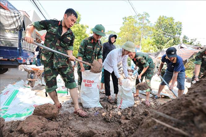 Trung đoàn 141 phối hợp cùng người dân gia cố đê tại thôn Ngô Đạo, xã Đa Phúc, Hà Nội. Ảnh: Lê Đông - TTXVN