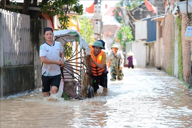 Người dân thôn Ngô Đạo, xã Đa Phúc, Hà Nội di chuyển đồ đạc, tài sản ra khỏi vùng ngập. Ảnh: Lê Đông - TTXVN