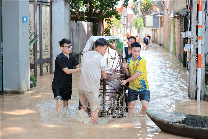 Người dân thôn Ngô Đạo, xã Đa Phúc, Hà Nội di chuyển đồ đạc, tài sản ra khỏi vùng ngập. Ảnh: Lê Đông - TTXVN