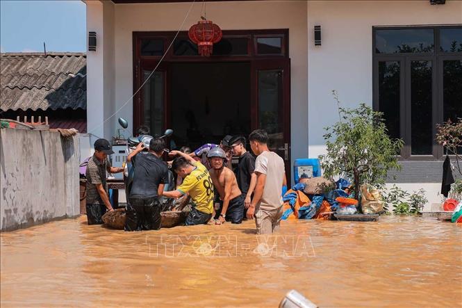 Người dân thôn Ngô Đạo, xã Đa Phúc, Hà Nội di chuyển tài sản khỏi vùng bị ngập. Ảnh: Hoàng Hiếu - TTXVN