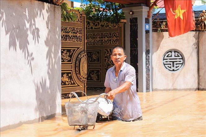Người dân thôn Ngô Đạo, xã Đa Phúc (Hà Nội) di chuyển tài sản khỏi vùng bị ngập. Ảnh: Hoàng Hiếu - TTXVN