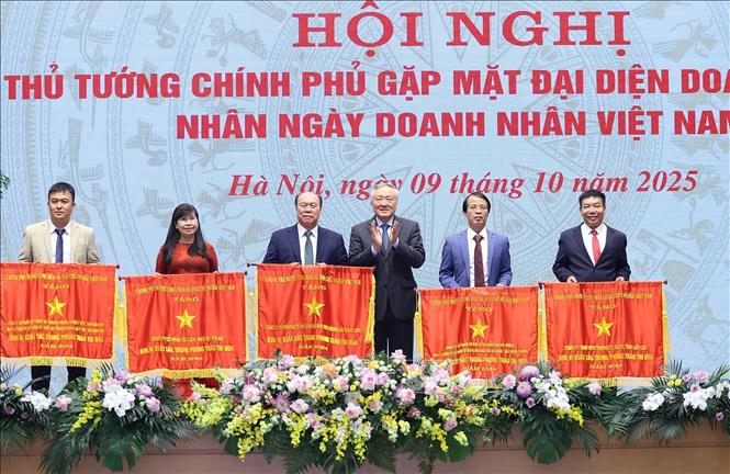 Phó Thủ tướng Thường trực Nguyễn Hoà Bình trao Cờ thi đua của Chính phủ cho các doanh nghiệp có thành tích xuất sắc. Ảnh: Dương Giang-TTXVN 

