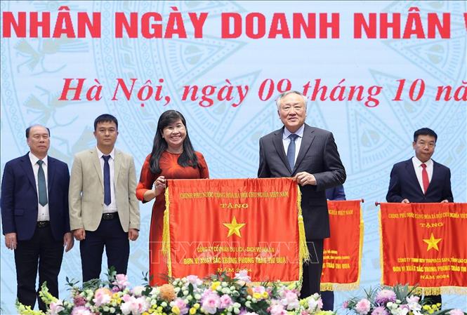 Phó Thủ tướng Thường trực Nguyễn Hoà Bình trao Cờ thi đua của Chính phủ cho các doanh nghiệp có thành tích xuất sắc. Ảnh: Dương Giang-TTXVN 
