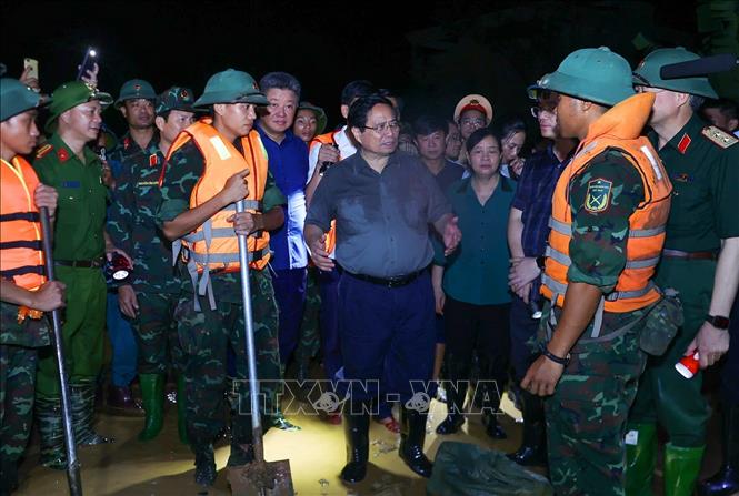 Thủ tướng Phạm Minh Chính chỉ đạo phòng chống lũ, ứng cứu sự cố, bảo đảm an toàn tuyến đê hữu Cầu. Ảnh: Dương Giang-TTXVN 

